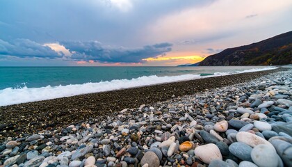Coastal sunset over a pebbled beach