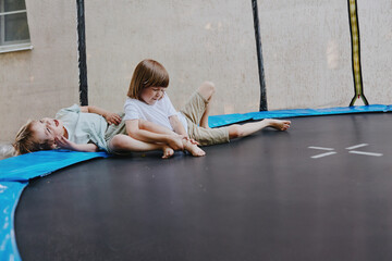 Happy children playing on a trampoline, enjoying their carefree childhood. The lively atmosphere captures the joy of outdoor activities and playtime moments.