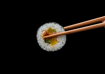 A cinematic shot of picking up a piece of kimbap against a black background