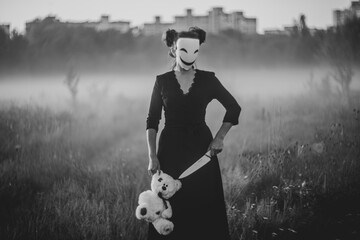 Spooky Halloween scene with mask, teddy bear, and knife