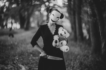 Spooky Halloween scene with mask, teddy bear, and knife