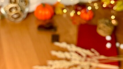 A vibrant autumn arrangement includes pumpkins, wheat stalks, and twinkling lights, creating a festive atmosphere perfect for seasonal gatherings in a cozy indoor location