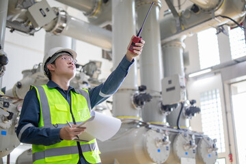 Engineer inspection substation equipment holding walkie talkie and document in industrial facility...