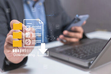A person is engaged in downloading digital files while using a laptop and smartphone, emphasizing technology and multitasking in a modern workspace.
