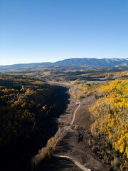 Aerial autumn landscape with winding road and mountains.