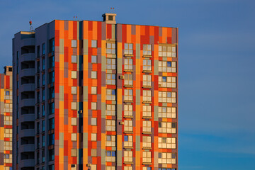 Modern buildings, walls and windows, reflections and sun rays. City view on a sunny day. 