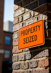 Property Seized Sign on Brick Wall warning notice
