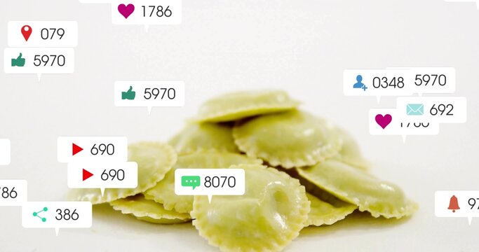 Floating social media icons circling pile of yellow ravioli squares on white surface, digital theme