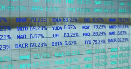 Displaying glass panel showing alphanumeric codes with percentages inside building, digital display