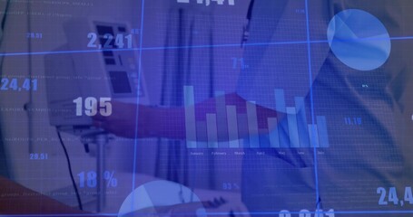 Collaborating partners typing and pointing at silver laptop in office, with floating finance charts