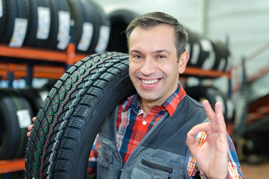portrait of smiling mechanic working with bike tires in workshop