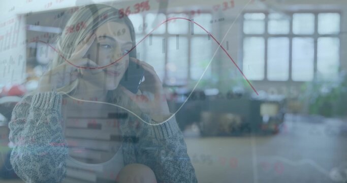 Talking woman in gray sweater, holding smartphone in open-plan office with data overlay, copy space