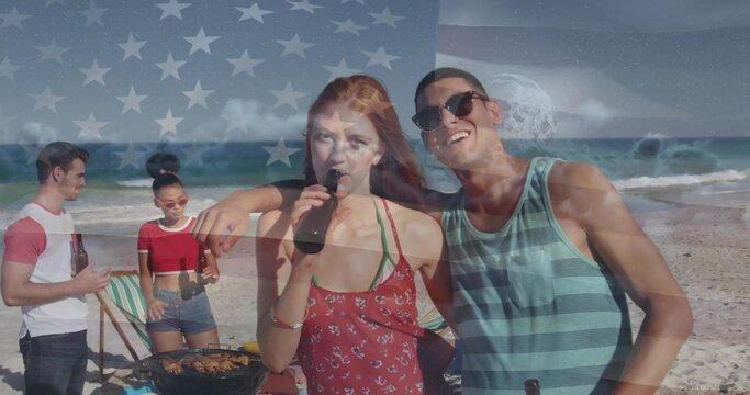 Sipping beer couple in red sundress and striped tank top chatting on sandy beach, with grill - Powered by Adobe