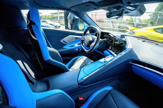 View of the interior of a Chevrolet Corvette racing supercar. Detail of the steering wheel with logo and control buttons.