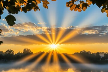 Golden sunrise breaks through clouds casting radiant rays over misty water and silhouetted trees