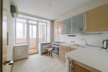 Bright kitchen featuring beige cabinets, tiled floors, and a balcony with a view