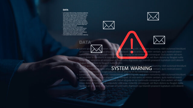 Hands of programmer receiving system warning with red exclamation mark triangle and email icons while typing on laptop keyboard in dark environment