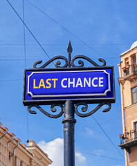 Obraz premium Last chance symbol. Concept word Last chance on beautiful blue road sign. Beautiful blue sky and buildings background. Business last chance concept. Copy space.
