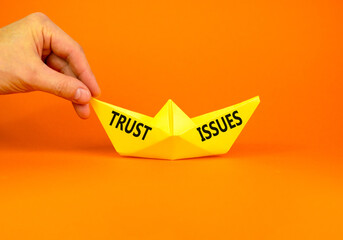 Trust issues symbol. Concept word Trust issues on beautiful yellow paper boat. Businessman's hand....