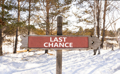 Last chance symbol. Concept word Last chance on beautiful wooden road sign. Beautiful snow winter forest background. Business last chance concept. Copy space.