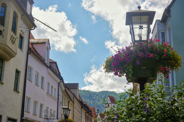Street lamp with flowers in old European town against blue sky
