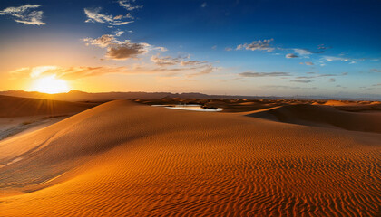 Majestic Desert Sunset Over Vast Rippled Sand Dunes With A Distant Oasis Reflecting The Warm Orange And Blue Hues Of The Sky