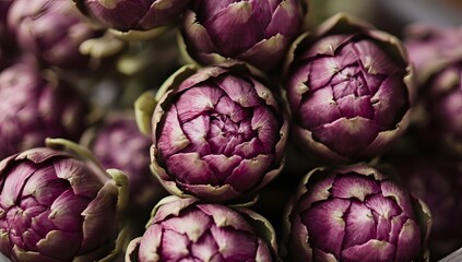 Obraz premium A vibrant cluster of fresh, raw artichokes with deep purple outer leaves, showcasing their intricate texture and natural beauty in a closeup view