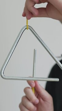 Student in a Navy Blue Shirt Ringing a Triangle