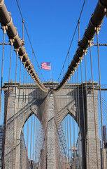 Obraz premium waving american flag above the Brooklyn Bridge iconic image of New York and