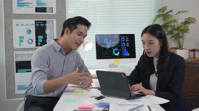 Professional team analyzing financial charts, working together on data driven project with digital tools in contemporary office environment - Powered by Adobe