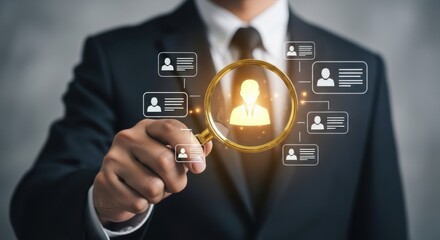 Businessman uses a magnifying glass to find the perfect candidate among many profiles