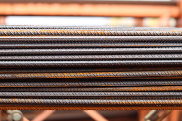 Reinforcement at the metal warehouse, selective focus. Construction iron rods with rust spots. Close-up of steel reinforcement. Warehouse of building materials. Repair and construction concept