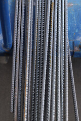 Reinforcement at the metal warehouse, selective focus. Construction iron rods with rust spots. Close-up of steel reinforcement. Warehouse of building materials. Repair and construction concept