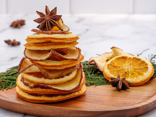 Background for personalized Christmas card. Tree decor of dehydrated dried orange and apple slices with star anise. Fall, Christmas, Thanksgiving seasonal decoration. Copy space. 