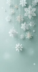 Paper snowflakes hanging on strings against a mint green background