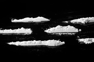 Several lines of cocaine on a black background