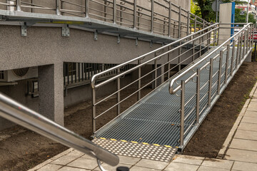 Obraz premium Accessible ramp for disabled people, metal ramp with handrails for strollers and disabled people,