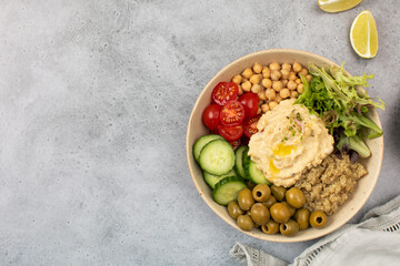 Colorful Buddha bowl with quinoa, hummus, chickpeas, vegetables. Healthy dish. Copy space