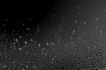 Obraz premium Black and white abstract background with water droplets on glass, minimalistic texture for design and creativity.