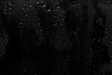 Fototapeta premium Black and white abstract background with water droplets on glass, minimalistic texture for design and creativity.