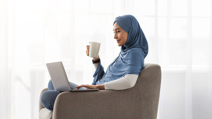 Comfortable workplace, rest in comfort, lazy, watch video, film. Happy millennial arab lady in...