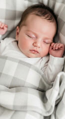 Close-up of a sleeping newborn baby wrapped in a grey and white checkered blanket, showcasing innocence, purity and peaceful sleep