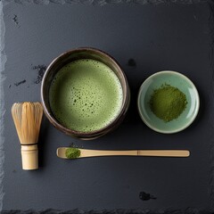 High-angle shot of a traditional Japanese green matcha tea set arranged on a dark slate surface.