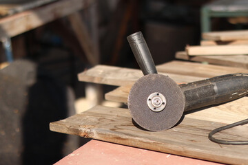 Angle grinders, power tools for construction and repair work. Tool for cutting and grinding hard materials. Old angle grinder with cord. Repair work in the country. Grinder with a metal disc