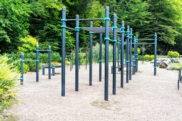 Street workout area with metal exercise structures located in a park. Sports equipment for bodyweight training, gymnastics, and healthy outdoor activity in an eco-friendly setting