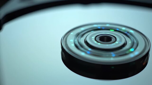 Close Up View of Circular Computer Hard Drive Rotating Under Soft Blue Lighting
