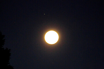 The luminous full moon illuminating the sky