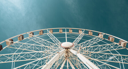 Ferris wheel against blue sky, low angle view of amusement park attraction © Marcin