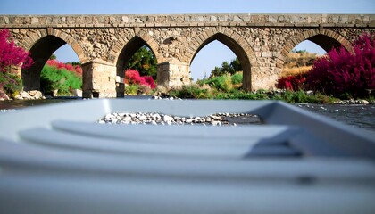 Ancient stone bridge over river, boat foreground
