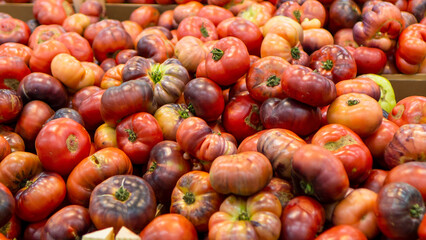 Large ripe tomatoes in a big pile lined up for sale,blurred background.